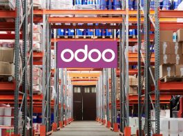 Workers using Odoo’s Manufacturing Module on a tablet to manage production and inventory in a modern factory setting