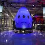 What’s Going On with SpaceX’s Dragon Spacecraft and Elon Musk’s New Plans? “SpaceX Dragon spacecraft floating in orbit above Earth with stars and space in the background.”