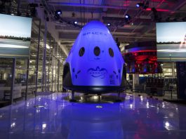 “SpaceX Dragon spacecraft floating in orbit above Earth with stars and space in the background.”
